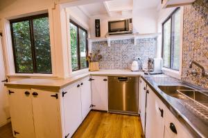 Pet-Friendly Highlands Home with Fireplace في بوندانون: مطبخ مع دواليب بيضاء ومغسلة
