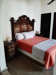 sypialnia z dużym łóżkiem z drewnianym zagłówkiem w obiekcie Hotel Boutique Edén Cuernavaca w mieście Cuernavaca