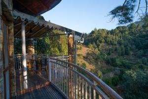 un balcone di una casa con vista sulle montagne di The Nature's Green Resort, Bhimtal, Nainital a Nainital