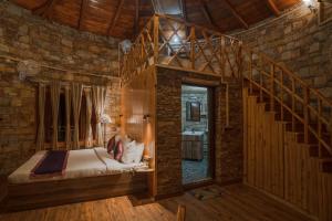 a bedroom with a bed and a wooden staircase at The Nature's Green Resort, Bhimtal, Nainital in Nainital