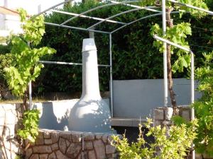 un grande vaso seduto di fronte a una serra di Apartments Biserka a Punat 1 altra foto