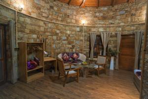 um quarto com uma parede de tijolos, uma mesa e cadeiras em The Nature's Green Resort, Bhimtal, Nainital em Nainital