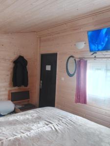 a bedroom with a bed and a flat screen tv at Pirts,kubls,,Saknēs,, in Talsi
