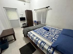 una camera da letto con un letto, una sedia e una finestra di Rodrigo Cottage a Negombo