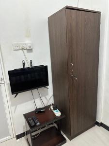 una camera con TV e mobile in legno di Rodrigo Cottage a Negombo