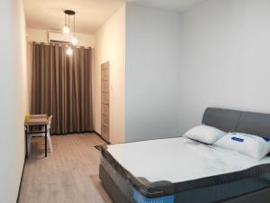 a bedroom with a bed and a desk in it at CEM MIRI HOMESTAY in Miri
