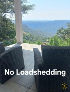 a porch with two chairs and a view of the mountains at Oribi Gorge Villa in Glendale