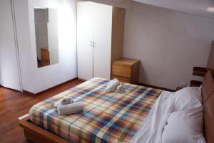 una camera da letto con un letto e due asciugamani di appartamento pietro e paolo a Livorno