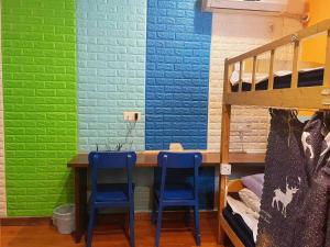 a bunk bed room with two blue chairs and a table at Ningbo 238 International Youth Hostel in Ningbo