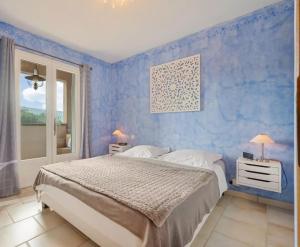 a bedroom with a bed and a blue wall at Clos des Lavandes - Luberon in Lacoste