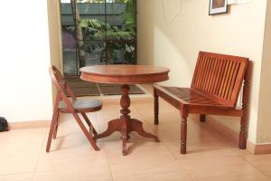 een tafel en een stoel naast een tafel en een stoel bij Wariyam Heritage in Trichūr