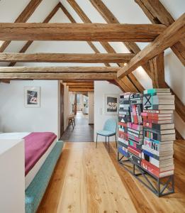 a bedroom with a bed and a stack of books at Engelwirt Hotel & Apartments in Berching