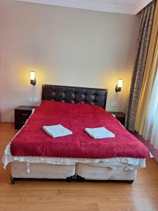 a bedroom with a red bed with two towels on it at Amir Apart Hotel in Istanbul