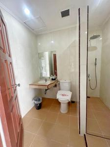 uma casa de banho com um WC, um lavatório e um chuveiro em Hotel Wisata Indah Sibolga em Sibolga