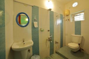 a bathroom with a toilet and a sink and a mirror at Bella Homestay Kerala in Alleppey