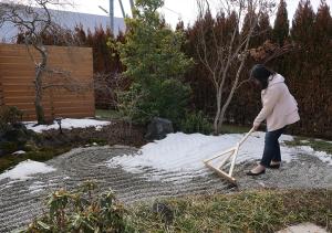 una mujer jugando con un bate de béisbol en la nieve en Hananoyado Yumefuji, en Fujikawaguchiko