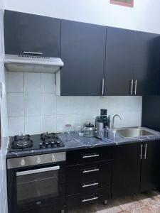 uma cozinha com um fogão e um lavatório em MozBnb em Maputo