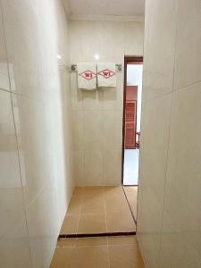 uma casa de banho com um chuveiro e 2 toalhas numa parede em Hotel Wisata Indah Sibolga em Sibolga