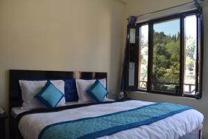 ChaukoriにあるAtithi Home Stay - Himalayas viewのベッドルーム1室(ベッド1台、大きな窓付)