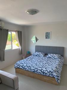 查龍的住宿－English owned Homestay and Yoga，一间卧室配有一张床、一张沙发和一个窗口