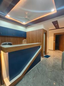 a kitchen with a blue counter and wooden cabinets at Hotel Hill View in Gandhinagar
