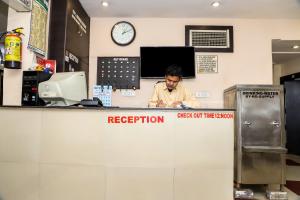 a man sitting at a reception counter in a store at OYO Hotel Duke Inn in Jhānsi