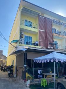 een gebouw met een tafel en een paraplu ervoor bij English owned Homestay and Yoga in Chalong 