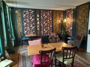 伯恩的住宿－蘭德豪斯酒店，餐厅配有桌椅和花卉壁纸