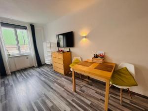 ウィーンにあるGemütliche Wohnung nähe Hauptbahnhof und Zentrumのテーブルと椅子とテレビのある部屋