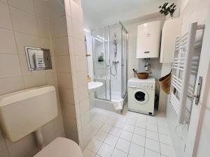 ウィーンにあるGemütliche Wohnung nähe Hauptbahnhof und Zentrumのバスルーム(トイレ、洗面台、洗濯機付)