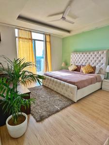 a bedroom with a large bed and a plant at Flamingo Hotel Sector 67 I Studio Rooms I Gurgaon in Gurgaon +31 photos