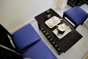 un tavolo con due sedie blu e un vassoio con tazze e caffè di Atithi Home Stay - Himalayas view a Chaukori