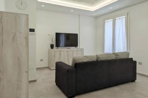 a living room with a couch and a flat screen tv at Minimal Apt Centro Wifi Clima by WeHostYou in Porto San Giorgio