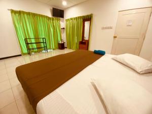 Cama grande en habitación con cortina verde en Adventure Base camp en Kitulgala