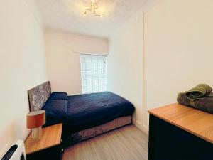 Un dormitorio con una cama azul y una ventana en Modern & Stylish 1 bedroom flat in Bridgend town, en Bridgend