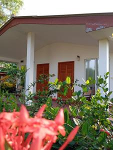 une maison avec des fleurs rouges devant elle dans l'établissement JEYs Place, à Nilaveli