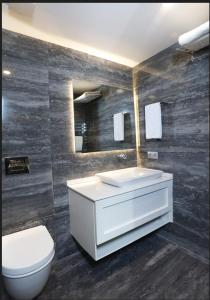 a bathroom with a white sink and a toilet at Riva Hotel Alsancak in İzmir