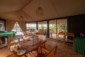 un comedor con mesas y sillas en una tienda de campaña en Serengeti Kifaru Tented Lodge en Mugumu