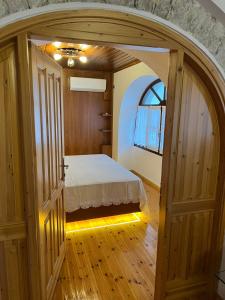 Un dormitorio con un arco y una cama. en Castle Hotel en Gjirokastër