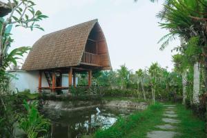 a house in the middle of a garden with a pond at Umadesa villa in Penginyahan