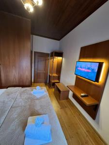 a bedroom with a bed and a flat screen tv at Castle Hotel in Gjirokastër