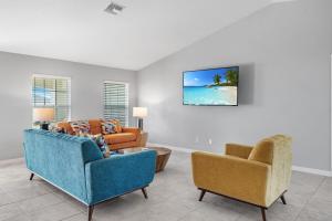 a living room with two chairs and a couch at The Cape Escape Pet-Friendly Sleeps 7 in Cape Coral +26 photos