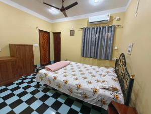 a bedroom with a bed and a checkered floor at Anjali Homestay in Siliguri