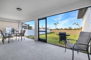 a living room with a table and chairs at The Cape Escape Pet-Friendly Sleeps 7 in Cape Coral