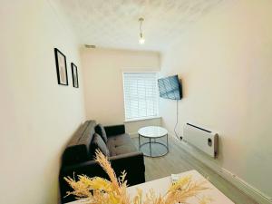 uma sala de estar com um sofá e uma mesa em Modern & Stylish 1 bedroom flat in Bridgend town em Bridgend