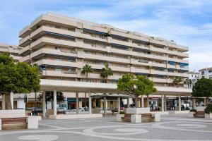 un gran edificio con árboles delante de él en Luminous apartment in Puerto Banús, Marbella en Marbella