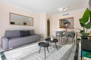 sala de estar con sofá, mesa y sillas en Luminous apartment in Puerto Banús, Marbella en Marbella