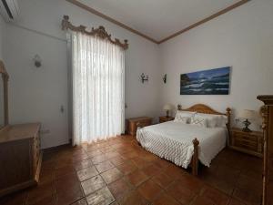 a bedroom with a bed and a large window at Garden Suites Xativa in Xàtiva