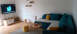 a living room with a blue couch and a tv at Vikendica DUNAV in Novi Sad