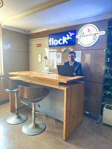 a man sitting at a desk with a laptop at Flamingo Hotel Sector 67 I Studio Rooms I Gurgaon in Gurgaon